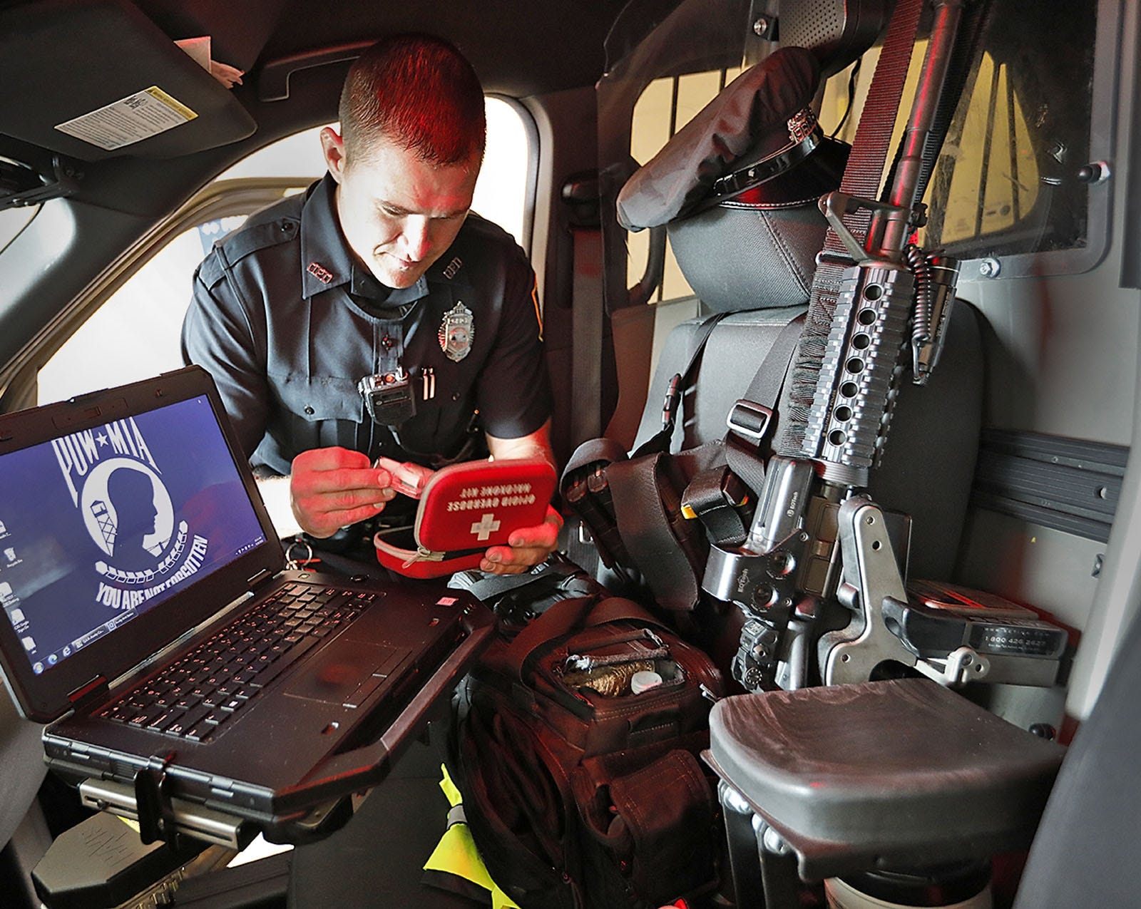 Quincy police officer Scott Kelley checks his Narcan supply at the beginning of his shift at the Quincy police station.