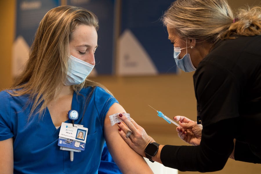 Nurse Debbie Mahoney administers a COVID-19 vaccine to nurse Alexa Zarlengo at Ascension Saint Thomas Hospital West in Nashville, Tenn., on Dec. 17.