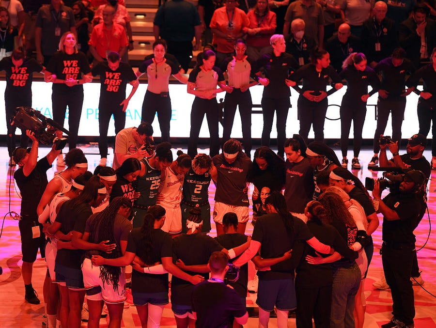 Players with the Connecticut Sun and Phoenix Mercury link arms for 42 seconds in honor of Phoenix Mercury center Brittney Griner before a WNBA basketball game Thursday, Aug. 4, 2022, in Uncasville, Conn.  Griner was convicted Thursday in Russia of drug possession and smuggling and was sentenced to nine years behind bars. (Sarah Gordon/The Day via AP)