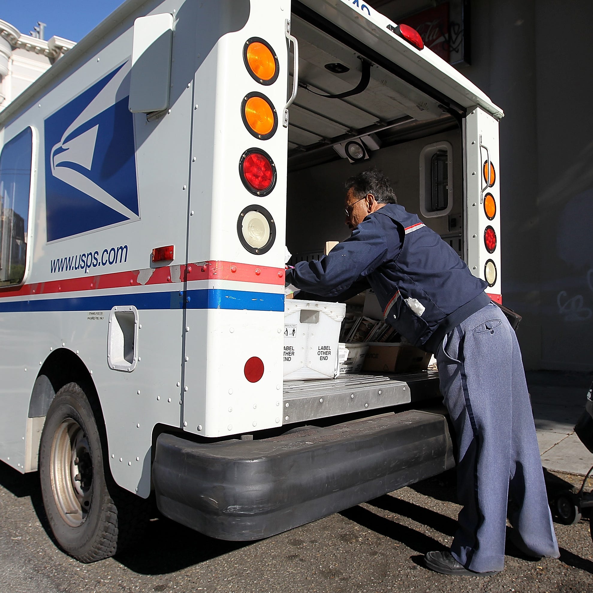 SAN FRANCISCO, CA - DECEMBER 05:  US Postal Service letter carrier Juan Padilla arranges mail in his truck while on his delivery route on December 5, 2011 in San Francisco, California. The US Postal Service announced today that they are considering a