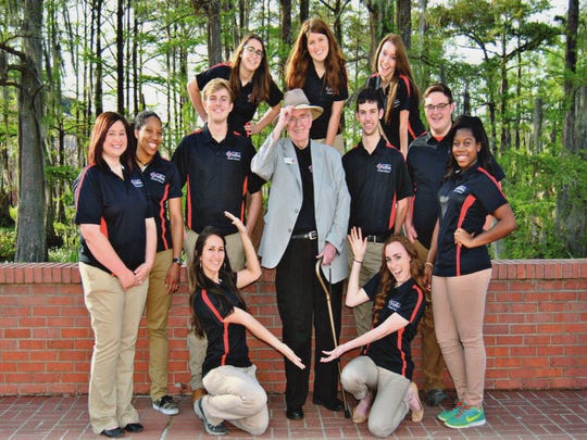 Charlie Lenox is surrounded by students/staff of the L'Acdien yearbook.