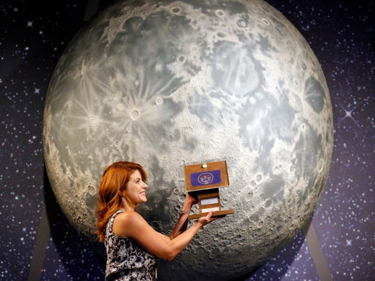 Lindsie Smith, of the Clark Planetarium, holds acrylic-coated moon rocks mounted on a wooden plaque at the Clark Planetarium in Salt Lake City. A former NASA investigator, who has spent more than a decade following the missing lunar rocks, is getting closer to his goal of finding the 50 lunar samples available in the United States after Neil Armstrong's first steps on the moon. In recent weeks, two other lunar rocks that fell from the radar after the Apollo 11 mission in 1969 were located in Louisiana and Utah.