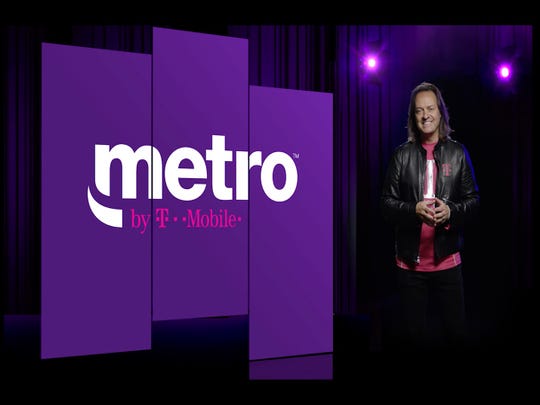 T-Mobile President and CEO John Legere poses next to the new Metro by T-Mobile logo. MetroPCS drops PCS when a name change.