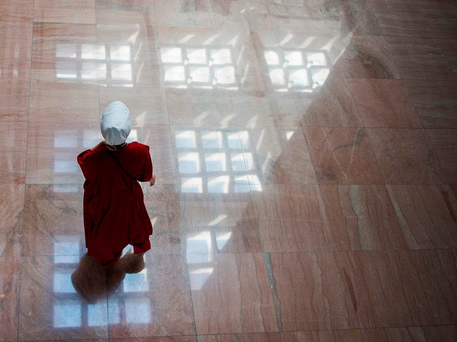 A protester dressed as a character from the novel-turned-TV series "The Handmaid's Tale" walks into the Senate Hart building during a rally against Supreme Court nominee Brett Kavanaugh on Capitol Hill in Washington, DC on October 4, 2018.