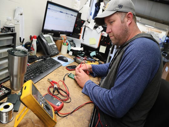 Jason Hamholm repairs a relay tester at Electronic Specialties in Genoa City. The company has been hit with a 25 percent tariff on products from China, seriously hurting the business and many others like it.