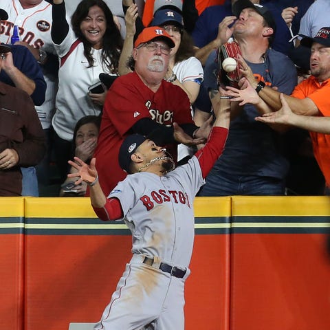 Red Sox right fielder Mookie Betts battles fans...