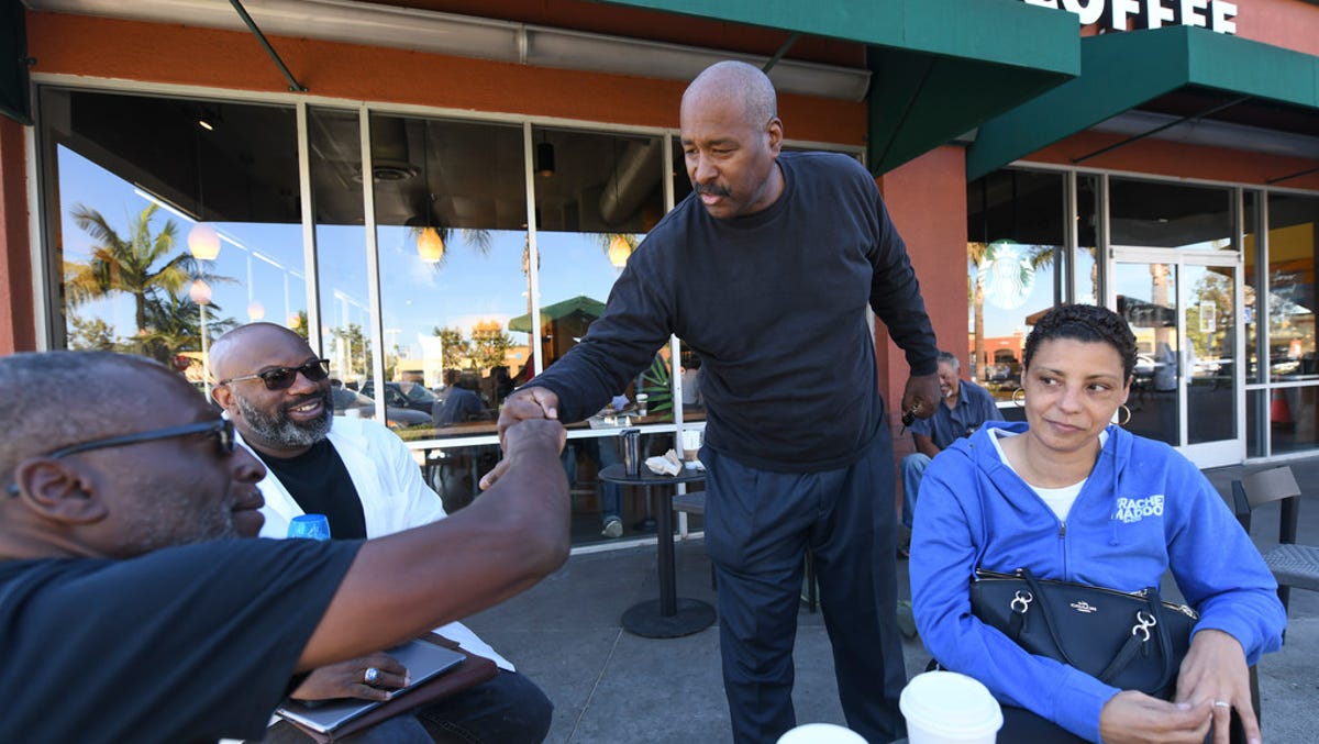 Fred Jackson, left, greets a friend in front of the Ladera Starbucks. The friends with Greg Medger Parrish, center, and Rosemary William have been gathering at that Starbucks since its opening in 1998.