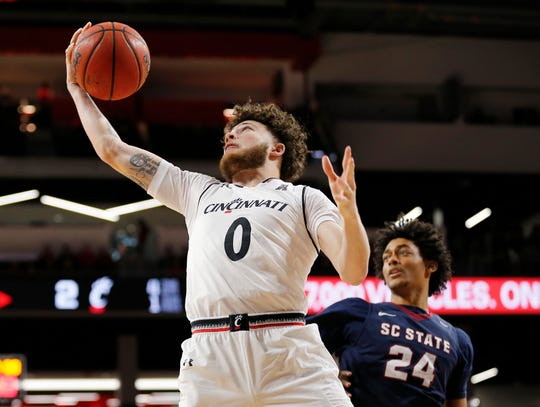 Cincinnati Bearcats guard Logan Johnson (0) pulls in a rebound in the first half of the NCAA basketball game between the Cincinnati Bearcats and the South Carolina State Bulldogs at Fifth Third Arena in Cincinnati on Saturday, Dec. 22, 2018. The Bearcats led 35-16 at halftime.