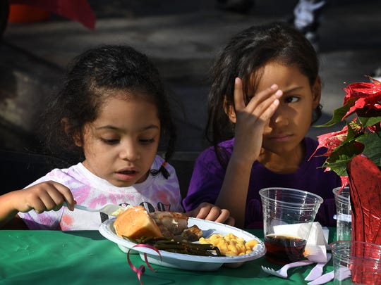 Children are among the desperately poor homeless who live on Los Angeles' Skid Row. They've been hurt by the teachers strike. Here are two enjoying a meal last month at a holiday feast event.