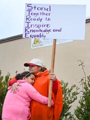 Second grade teacher Rosa Rubalcava hugs her daughter Alina Ramirez as she stands on the picket line at Telfair Elementary School. Alina is a student at the school.