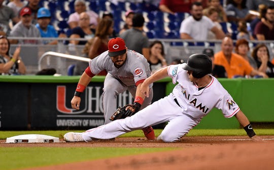 Sep 20, 2018; Miami, FL, USA; Miami Marlins catcher J.T. Realmuto (11) slides in to third base safely ahead of the tag of Cincinnati Reds third baseman Eugenio Suarez (7) in the first inning at Marlins Park. Mandatory Credit: Jasen Vinlove-USA TODAY Sports