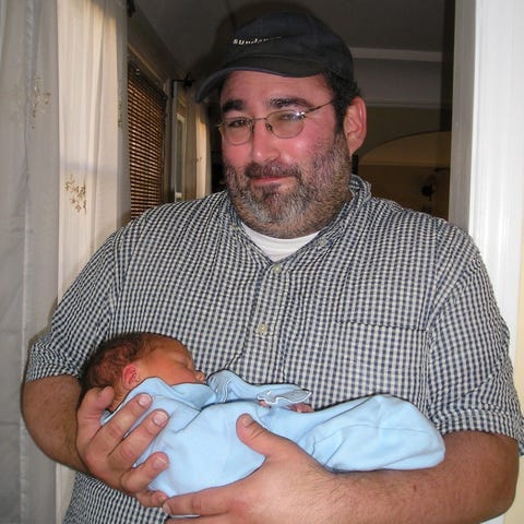 Lee Stern holds a friend's newborn in Los...