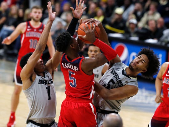 Colorado guard D'Shawn Schwartz, right, riches up to block a shot by Arizona guard Brandon Randolph, center, as Colorado guard Tyler Bey defends in the first half of an NCAA college basketball game Sunday, Feb. 17, 2019, in Boulder, Colo.