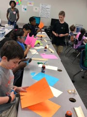 Students make aqueducts out of construction paper before running water through them as a test. The activity was part of David Thibodaux STEM Magnet Academy's free Saturday camps hosted four times this school year.