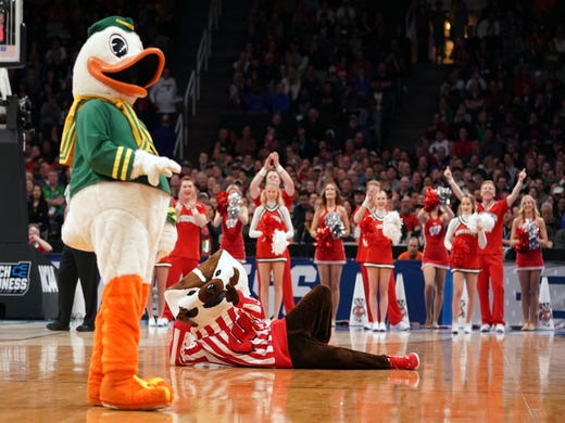 First round: The Oregon and Wisconsin mascots perform during a stoppage in play.