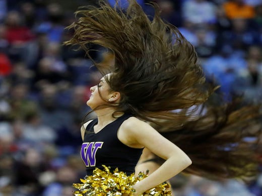 First round: A Washington Huskies cheerleader performs during the game against the Utah State Aggies.