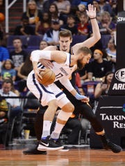 Mar 30, 2019; Phoenix, AZ, USA; Memphis Grizzlies center Jonas Valanciunas (17) dribbles against Phoenix Suns forward Dragan Bender (35) during the first half at Talking Stick Resort Arena. Mandatory Credit: Joe Camporeale-USA TODAY Sports