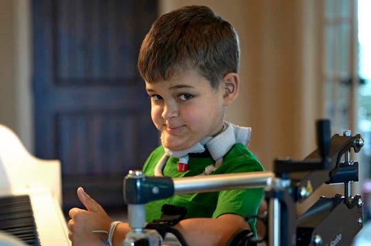 Braden Scott raises his thumbs while he practices the piano in Tomball, Texas on Friday, March 29, 2019. Braden was diagnosed with the mysterious syndrome called Acute Flaccid Myelitis, or AFM, in 2016 and was almost completely paralyzed. But since then, he has regained much of his muscle function.