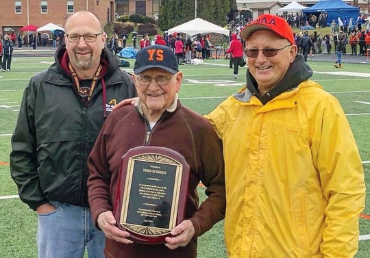 Herb Schmidt, center, is shown while being honored with a plaque to commemorate the 60th running of the Herb Schmidt Relays. The event was held at York Suburban High School. Pictured with Schmdt were Josh Leik, left, and Dave Wickenheiser.