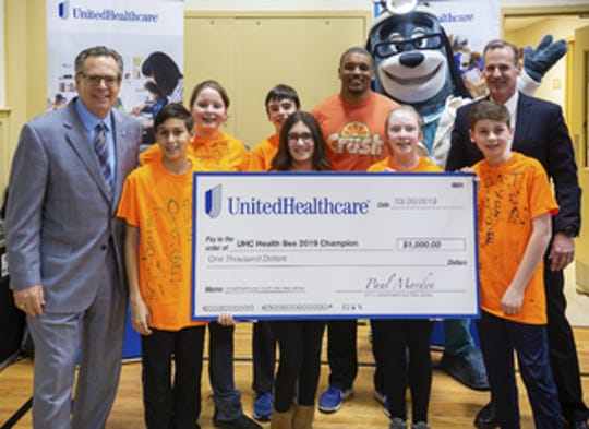 Mark Elsasser, CEO, Westfield Area YMCA (far left), Paul Marden, CEO, UnitedHealthcare of New Jersey (far right) and UnitedHealthcare’s mascot Dr. Health E Hound celebrate with a team of seventh graders from Orange Avenue School who won the 2019 UnitedHealthcare Health Bee in overtime at the Westfield YMCA.. UnitedHealthcare awarded Orange Avenue School funding for its health and wellness programs with a $1,000 grand prize.