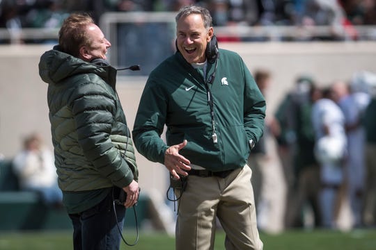 Michigan State men's basketball head coach Tom Izzo, left, jokes with football head coach Mark Dantonio during the annual Michigan State Green-White spring football game last April at Spartan Stadium in East Lansing.