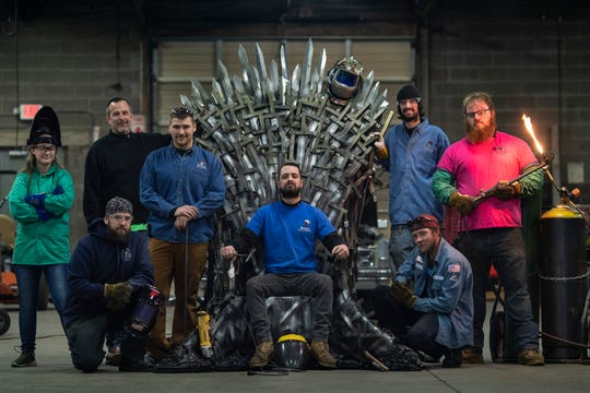 Knight School of Welding student Dayle Gray, from left, owner Matt Hobbs, students Anthony Williams, Kyle Fox, Eddie Knight, Daren Hobbs, Jesse Loghry, and Jeff Smith stand with their full-size replica of the Iron Throne.