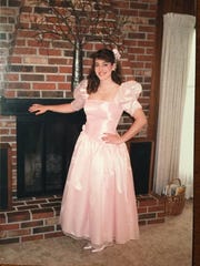 Betsy Crapps poses in her pink gown before her 1988 senior prom in Rochester, New York. The pink gown is her mainstay for the annual Mom Prom in Canton — along with purple low-top Chuck Taylor sneakers.