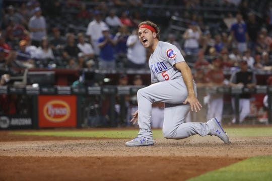 Cubs' Albert Almora Jr. (5) slides in scoring and celebrating against the Diamondbacks during the 15th inning at Chase Field in Phoenix, Ariz. on April 28, 2019.