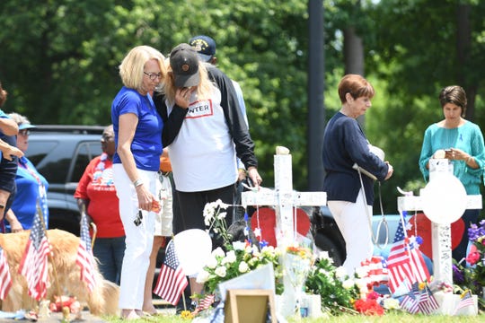 People stop in front of the City Center memorial to pay tribute to June 3, 2019, for the victims of Mass in Virginia Beach, Virginia. 