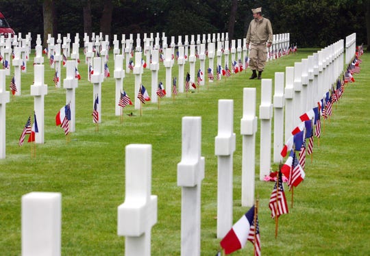 An unidentified visitor wearing a U.S. military nurse uniform walks past graves at the American cemetery, in Colleville-sur-Mer, western France, on June 6, 2007 .