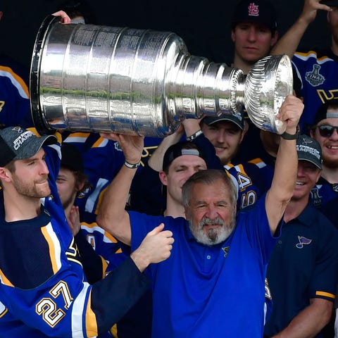 Former Blues great Bob Plager lifts the Cup.