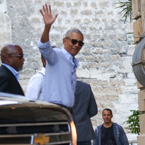 Former President Barack Obama waves during a...