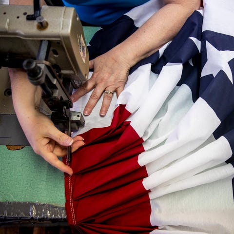 Rita Howard sews American flag bunting or fan...