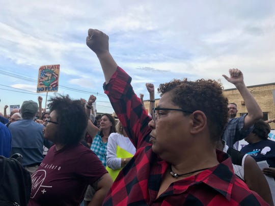 Demonstrators gather outside the Elizabeth immigration detention center on July 2, 2019 as part of nationwide "Close the Camps" events. They raise their arm as airplanes fly overhead to show their solidarity with immigration detainees.