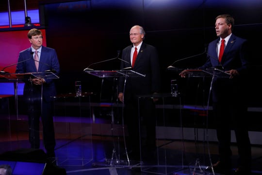 Lt. Gov. Tate Reeves, left, and former state Supreme Court Chief Justice Bill Waller Jr., center, listen to Rep. Robert Foster, R-Hernando, answer a question during a GOP gubernatorial primary debate in Jackson, Miss., Tuesday, July 23, 2019.