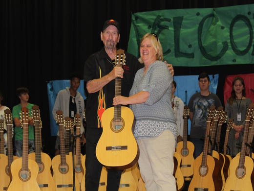 James Burton, Rock and Roll Hall of Famer, presents 60 guitars to music educator Vicki Kirkendall for student-lessons at North Caddo Elementary Middle School in Vivian.