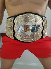 Frank Price posed for this torso-only photo of him wearing the AEW championship belt.