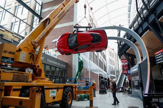 Workers install the 2020 Corvette Stingray on the wall at the northeast entrance of the Little Caesars Arena in downtown Detroit, Tuesday, September 10, 2019.