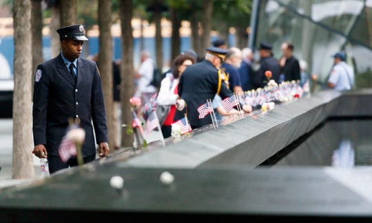 A firefighter walks past the South Pool during ceremonies at the National 9/11 Memorial marking the 18th anniversary of the September 11, 2001 terrorist attacks in New York.