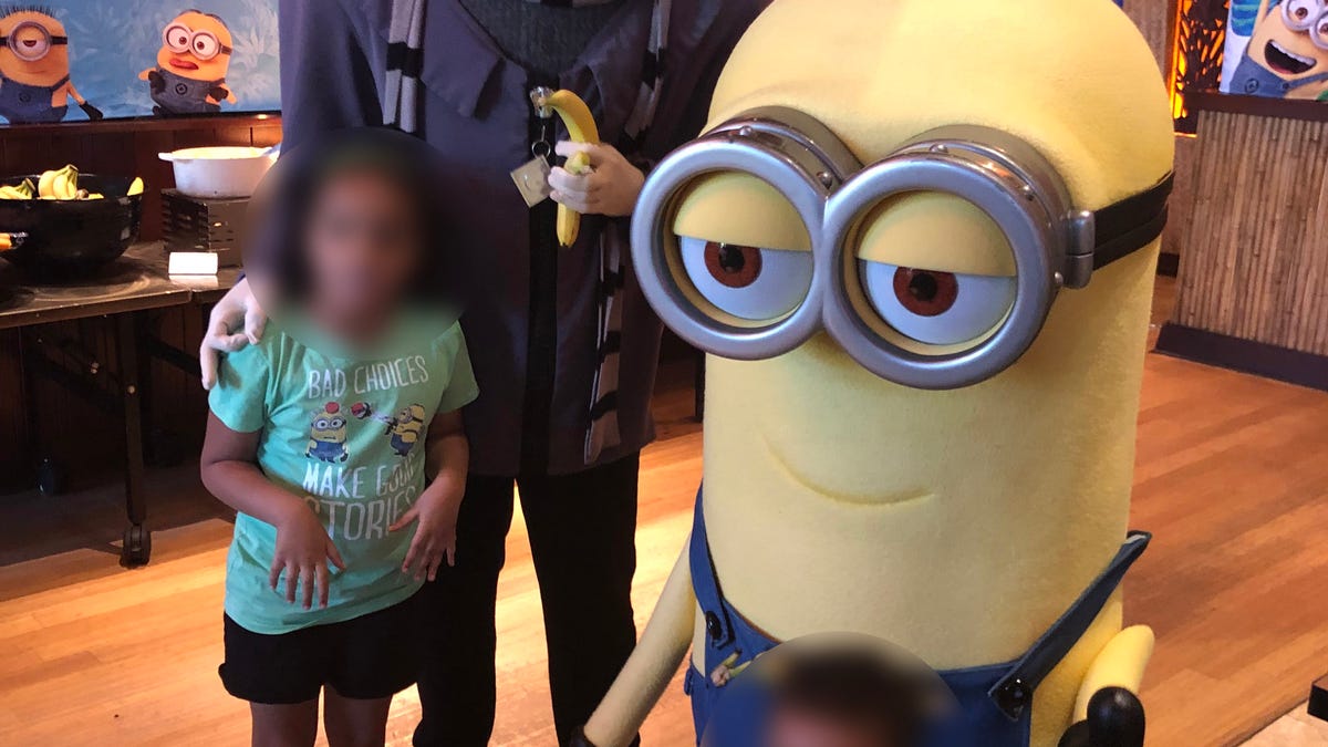 The photo shows the Gru character making the symbol on the 6-year-old's shoulder.