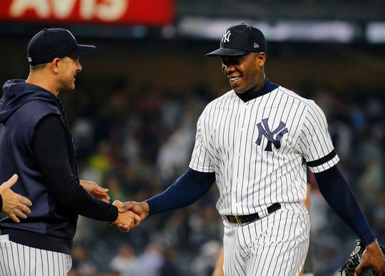 New York Yankees relief pitcher Aroldis Chapman (54) is congratulated by manager Aaron Boone after getting the save against the Boston Red Sox at Yankee Stadium on June 1, 2019.