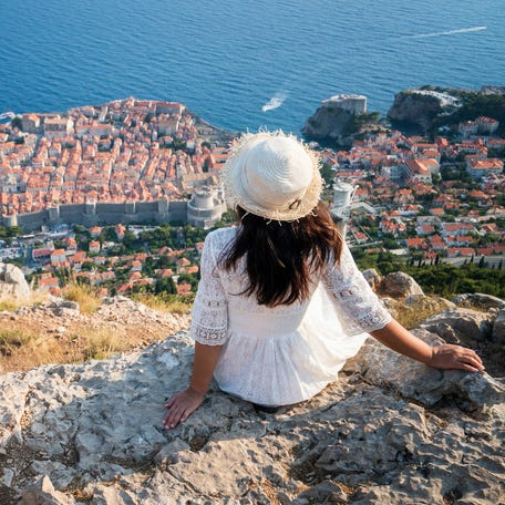 Traveller looking at view of Dubrovnik Old Town, in Dalmatia, Croatia, the prominent travel destination of Croatia. Dubrovnik old town was listed as UNESCO World Heritage Sites in 1979.