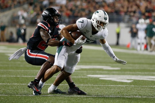 Ohio State defensive back Cameron Brown, left, tackles Michigan State receiver Cody White during the second half Saturday night.