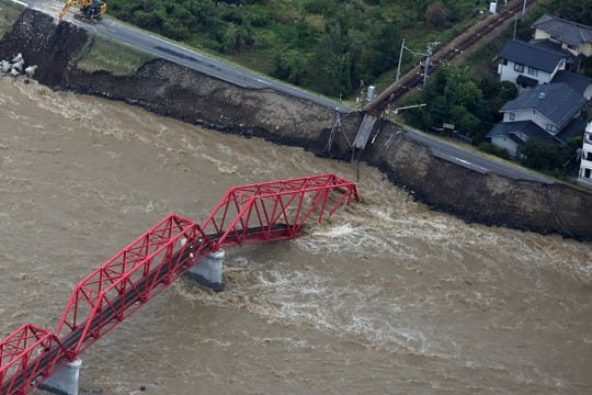 This aerial view shows a damaged train bridge over the swollen Chikuma river in the aftermath of Typhoon Hagibis in Ueda, Nagano prefecture on October 13, 2019.