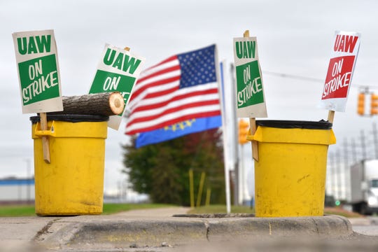 The U.S. and UAW flags blow in the wind in behind 'UAW On Strike' picket signs at the GM Warren Transmission Operations plant before picketers hear there may be a tentative deal to end the strike.