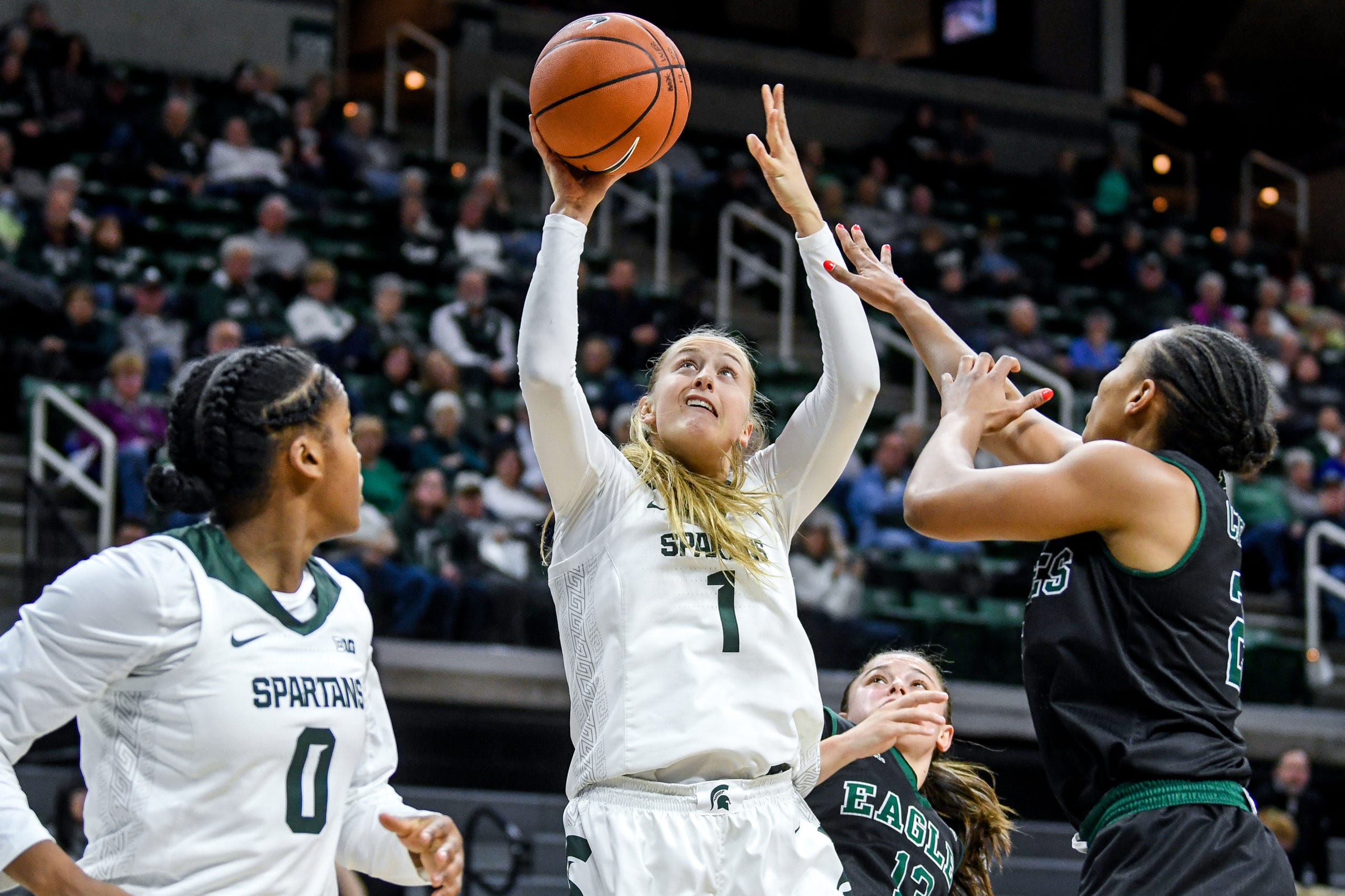 Michigan State's Tory Ozment, center, scores as Eastern Michigan's Corrione Cardwell defends during the  fourth quarter on Tuesday, Nov. 5, 2019, at the Breslin Center in East Lansing.