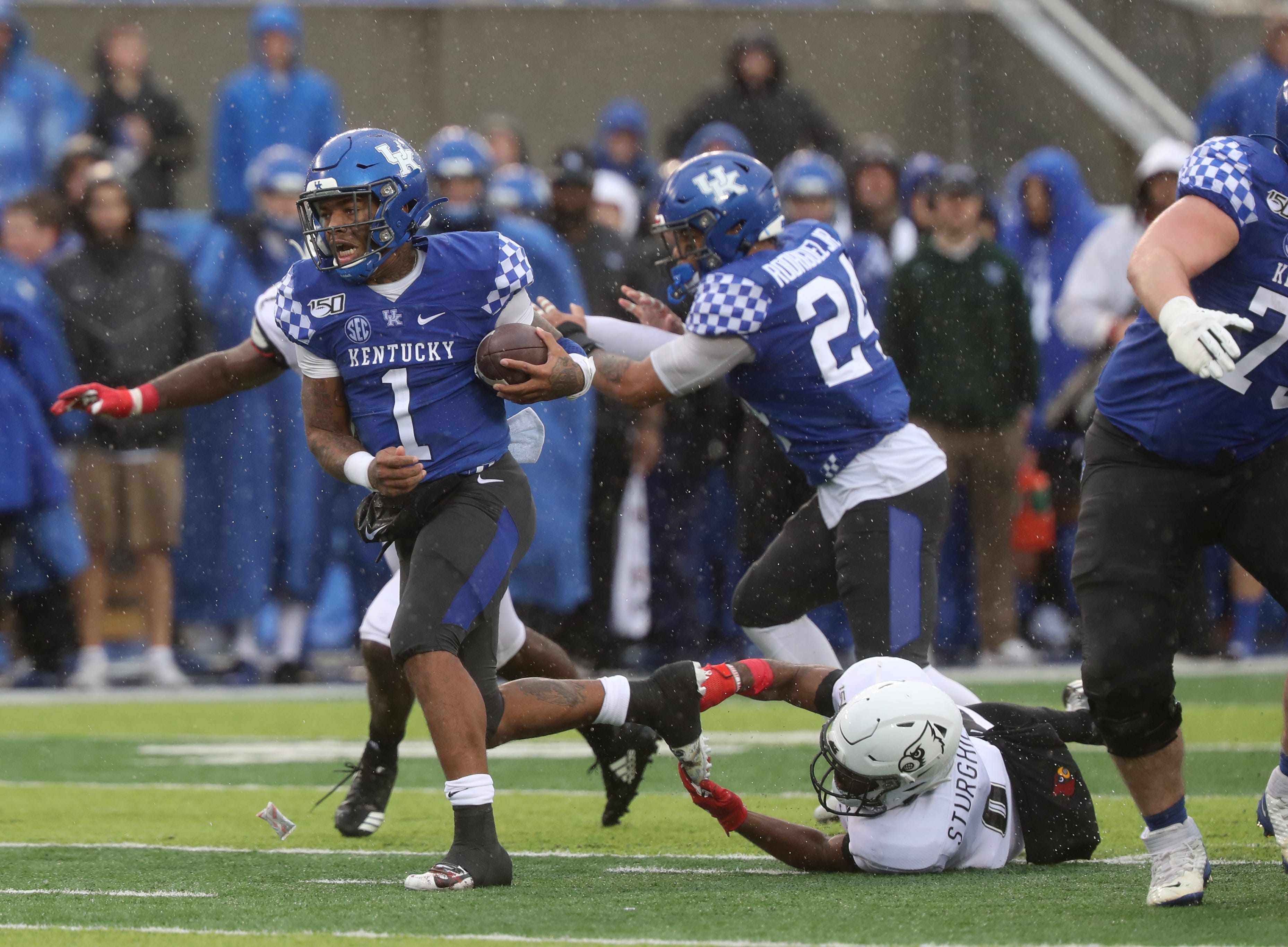 Kentucky running back Benny Snell Jr. , his face wrapped in a scarf, greets  fans before the