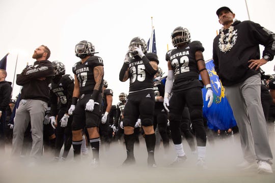 Nevada head coach Jay Norvell, right, and his team prepare to take the field against UNLV on Saturday.