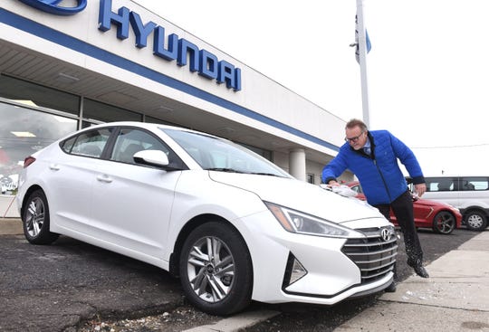 Joe Busch, sales consultant at LaFontaine Hyundai in Dearborn, wipes the ice off of a 2020 Elantra SEL Tuesday. Hyundai saw sales of its compact car increase 102% this November over last year.