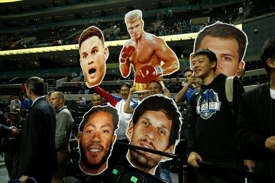 Fans hold cardboard heads of players from the Dallas Mavericks and Detroit Pistons prior to Thursday's game in Mexico City.